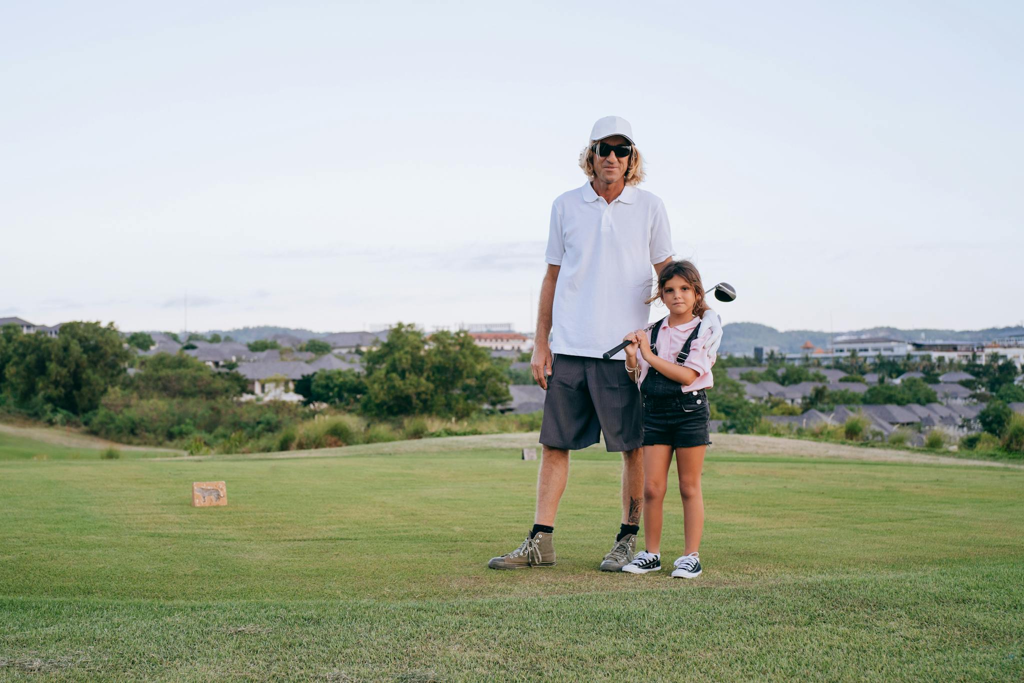 Father and daughter enjoying a day golfing together, illustrating family bonding and leisure outdoors.